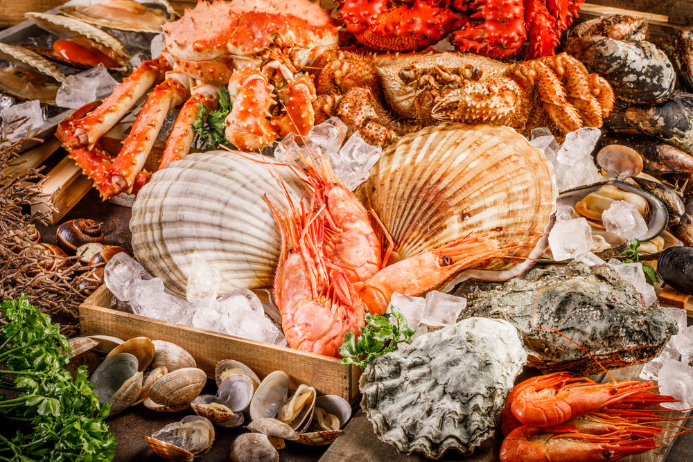 A Beginner's Guide to Southern Seafood Traditions - Seafood cuisine plate as an ocean gourmet dinner background. Crab, seashells, oysters, shrimp and other seafood delicacies.