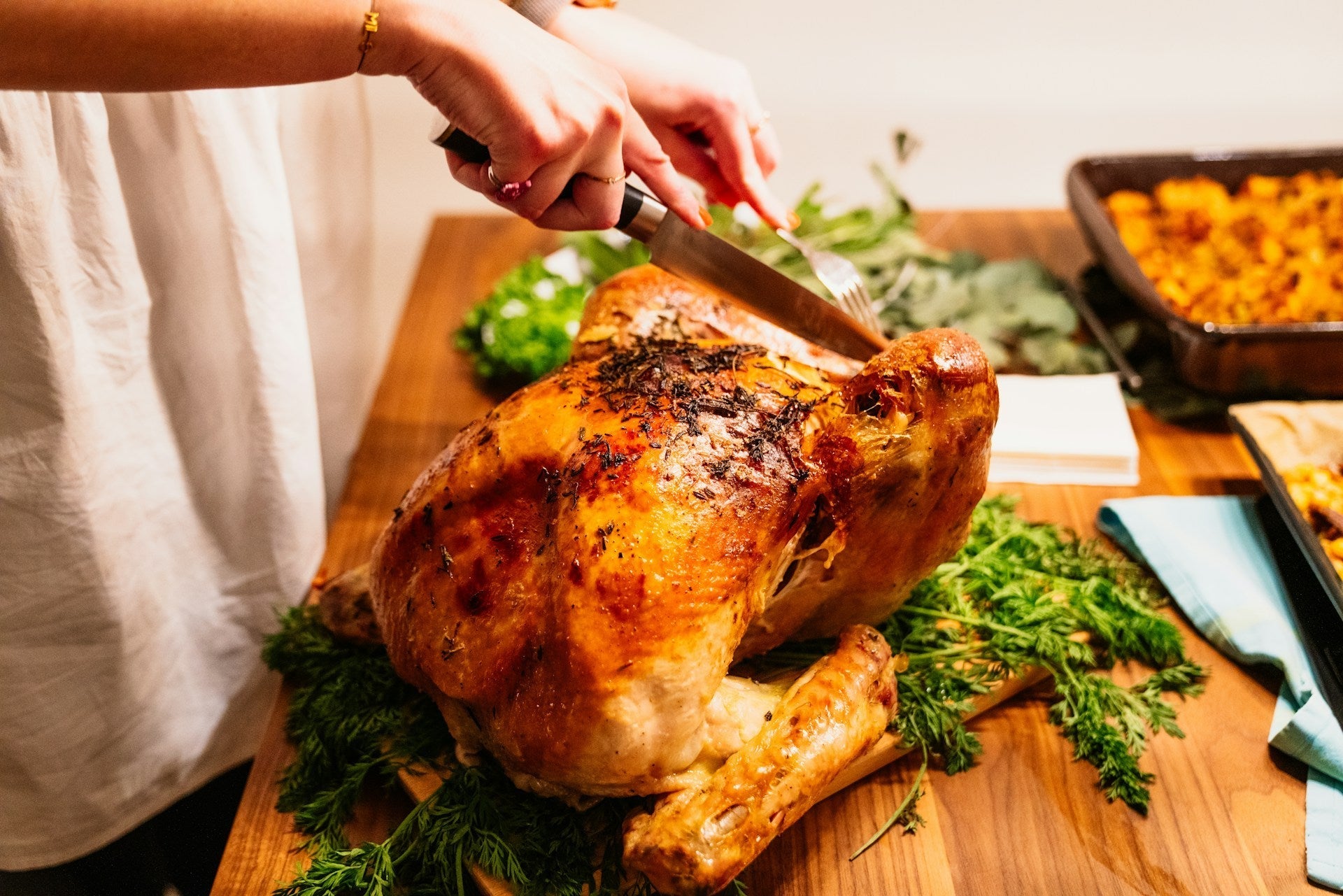Woman slicing into a turkey made in a turkey fryer