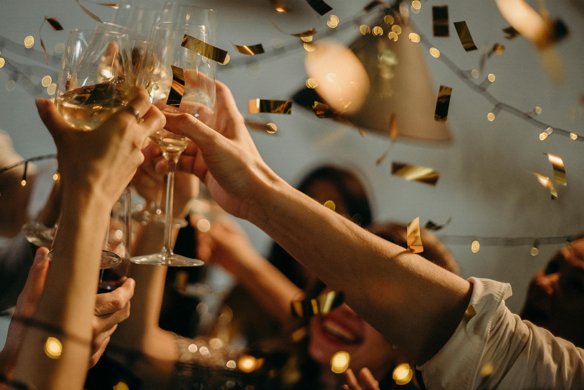 Guests at a New Year’s Eve party toasting Champagne glasses