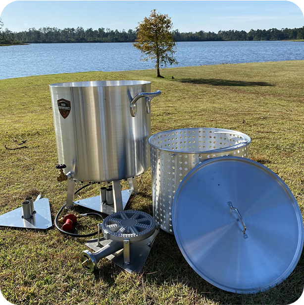 seafood boil equipment laid out on the grass next to a river