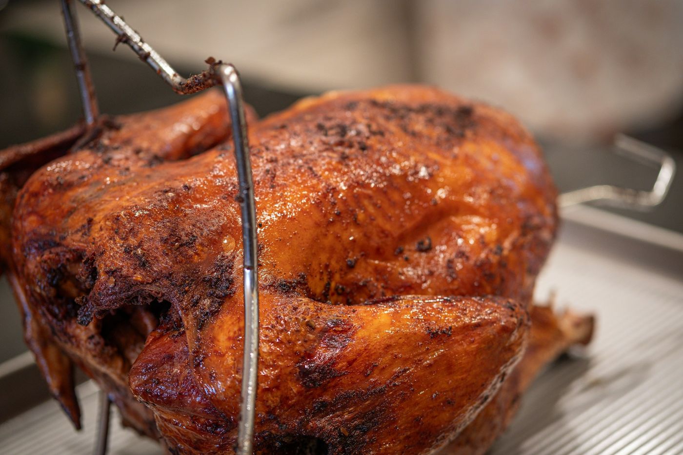 A golden-brown fried turkey on its rack, fresh out of the oil